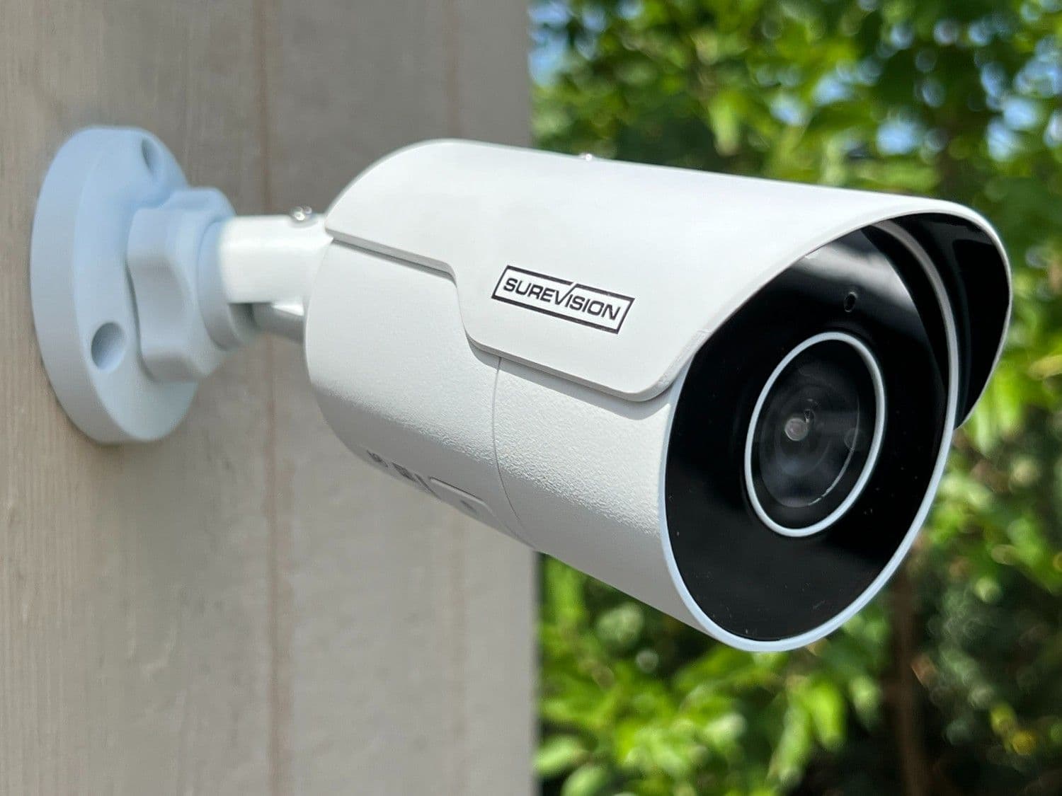 Outdoor wireless security camera mounted on a house wall for home surveillance and property monitoring.