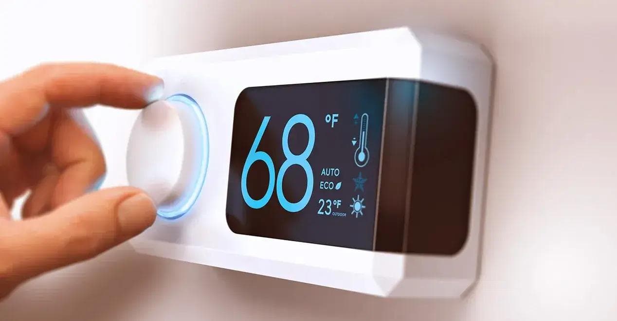 Person adjusting a smart thermostat display to optimize home temperature and energy efficiency