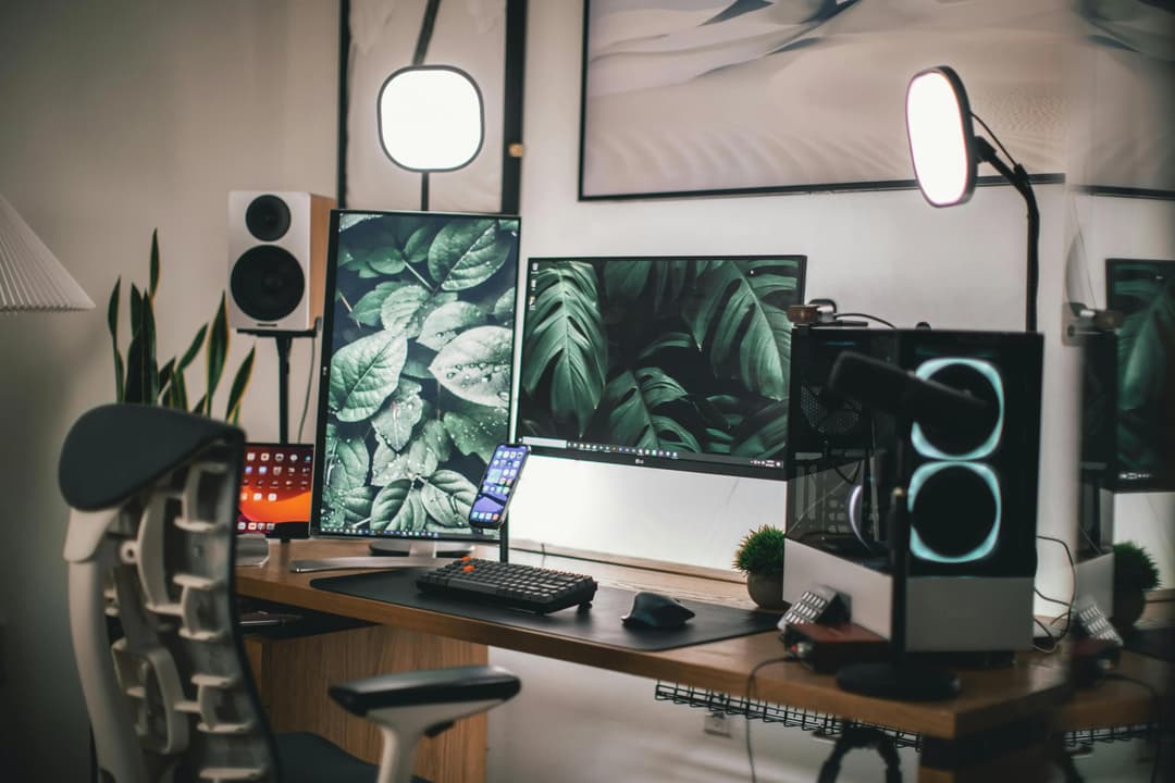 Modern home office setup with dual monitors, desktop computer, lighting, and organized workspace for remote work