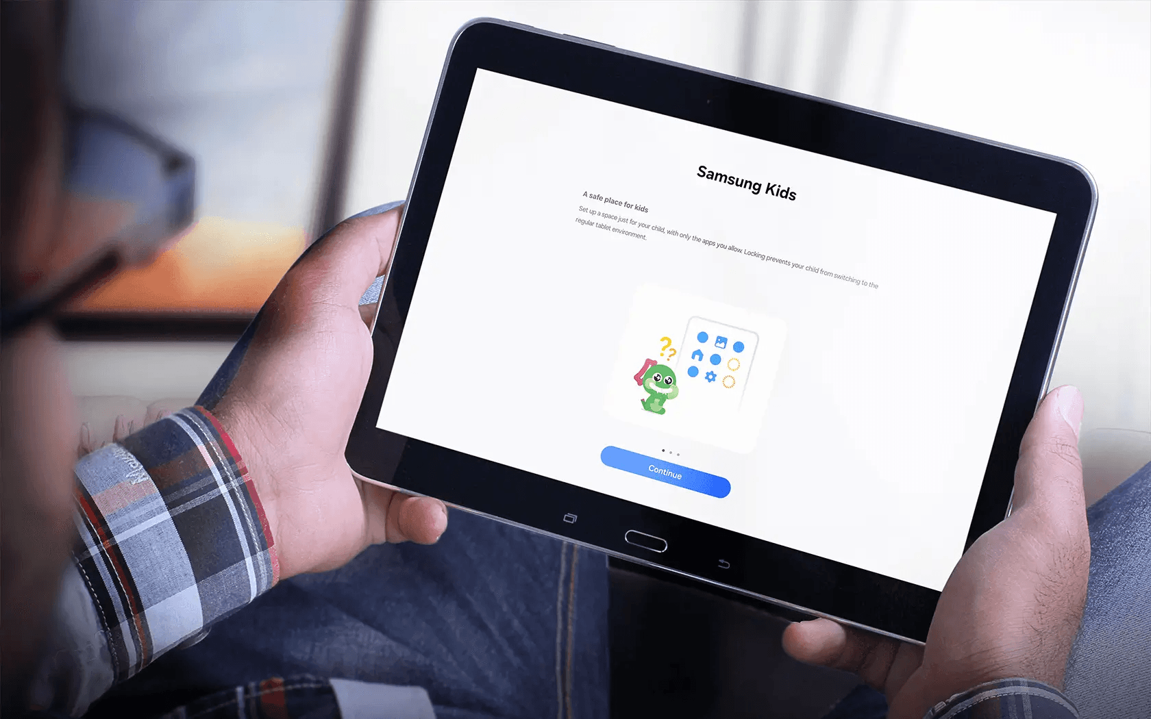 Hands holding a tablet displaying Samsung Kids setup screen